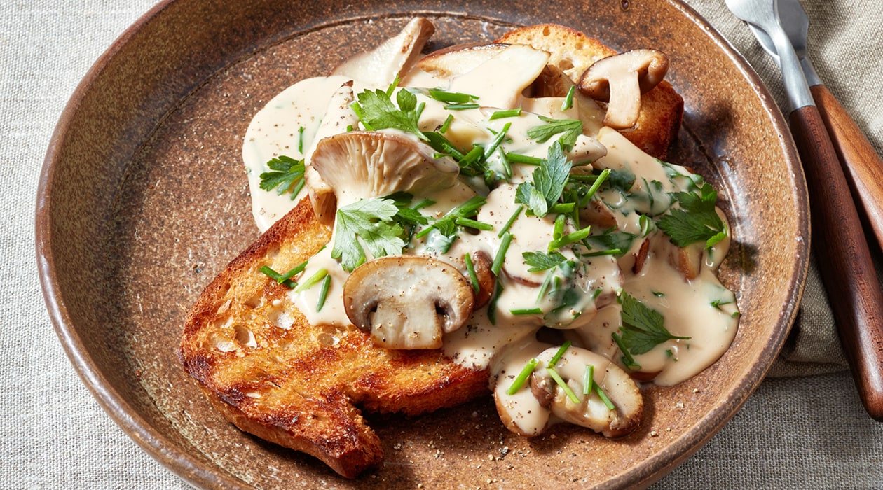 Gebakken paddenstoelen in een romige saus op zuurdesem toast – Recept